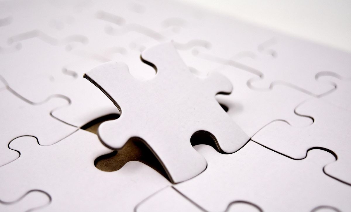 Einzelnes Puzzleteil über einer Lücke – Symbol für das zusammenfügende Element